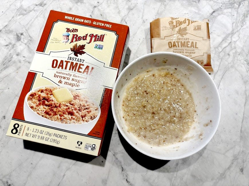 Red Mill oatmeal box next to empty packet and bowl of oatmeal 