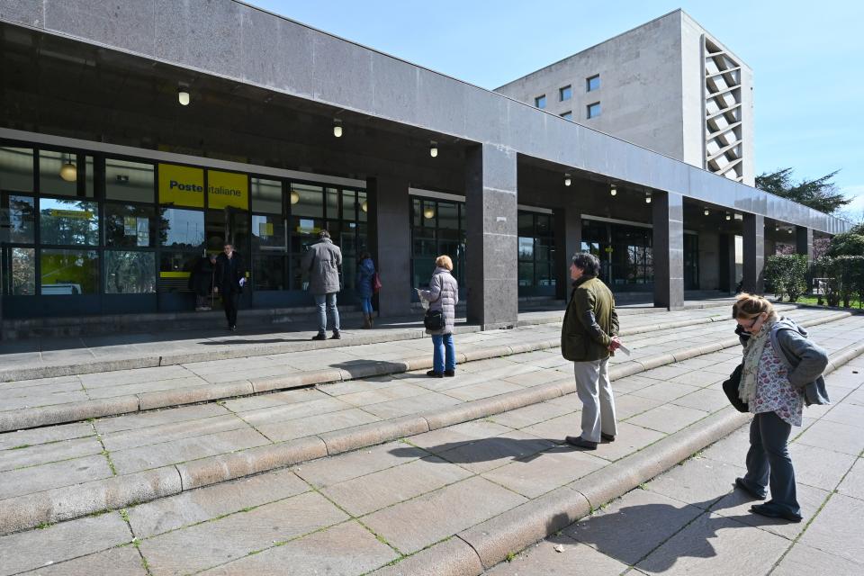 People keep a safe distance while lining up to enter a post office in downtown Rome on March 10, 2020. (Credit: Alberto Pizzoli/AFP)