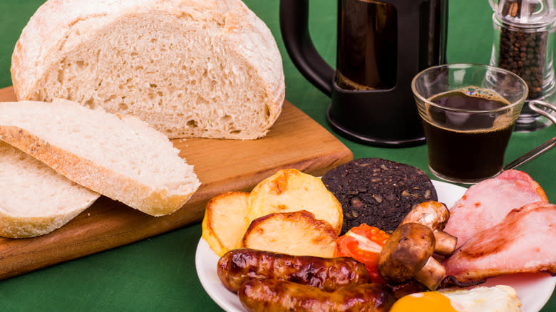 Ulster fry with soda bread and coffee on green background