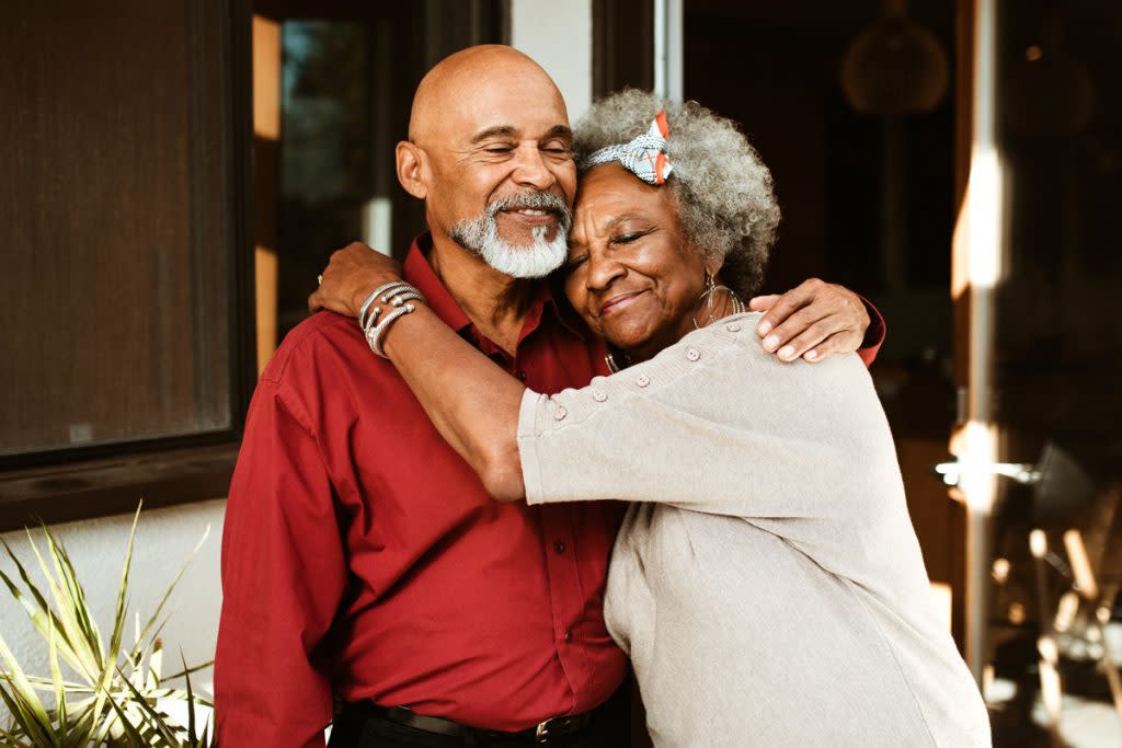 A senior citizen age couple hug one another at their home. This story explains how social security works.