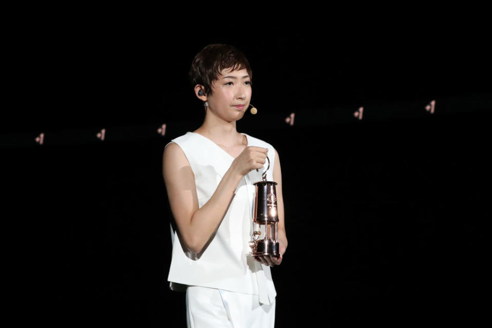 Swimmer Rikako Ikee of Japan, who is recovering from Leukemia, holds up a lantern containing the Olympic Flame during an event marking one year to go to the Tokyo Olympic Games at the National Stadium on July 23, 2020 in Tokyo, Japan.<span class="copyright">Du Xiaoyi–Pool/Getty Images</span>