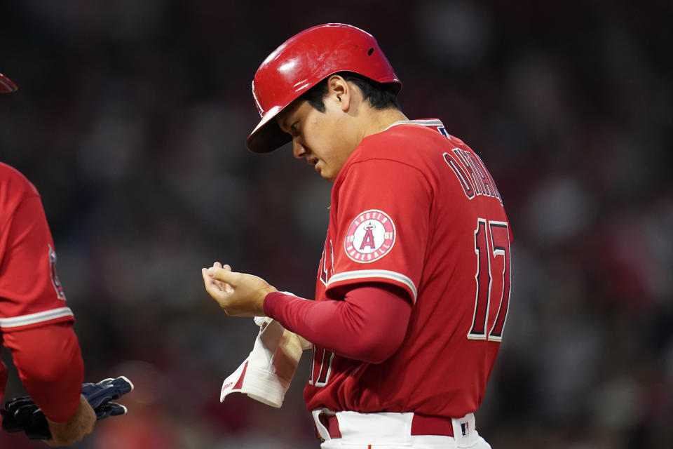 Los Angeles Angels designated hitter Shohei Ohtani (17) looks at his left hand after running to first base on a single during the fourth inning of a baseball game against the Tampa Bay Rays in Anaheim, Calif., Tuesday, May 10, 2022. (AP Photo/Ashley Landis)