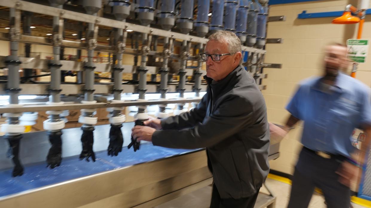 Jim Hull, President of Summit Glove, fits sample gloves onto a tensile-testing machine. Summit Glove, a Minerva, Ohio-based company, is a consultant at the Madison Correctional Institution in London where they are building a factory to produce gloves. The prison uses Summit's intellectual property and formulas to manufacture gloves that will be used by corrections officers and prison staff.