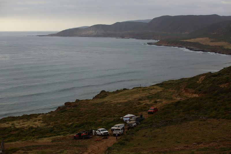 Members of a rescue team work at a site where three bodies were found, in La Bocana