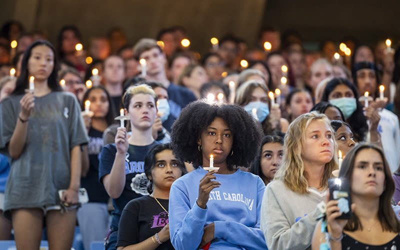 University of North Carolina-Chapel Hill students, faculty and family hold candles during a vigil