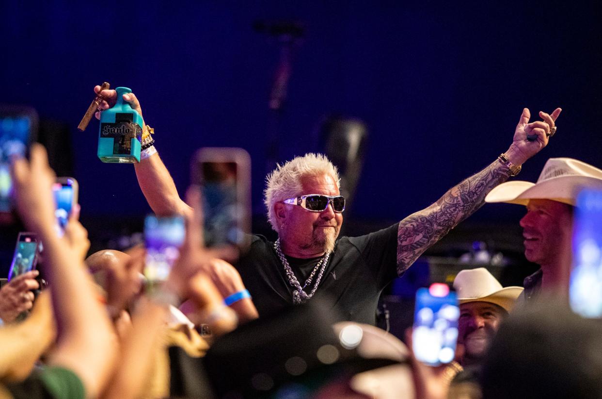 Guy Fieri pours shots of tequila for fans waiting for Chris Stapleton's performance at the 2023 Stagecoach festival in Indio, California.