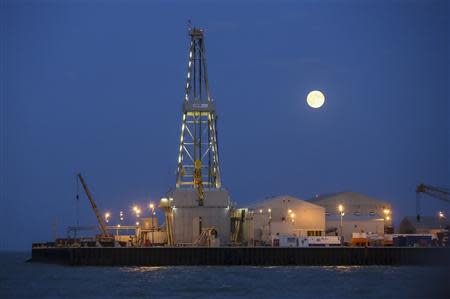 The full moon rises in the background over an oil rig at the Kashagan offshore oil field in the Caspian sea in western Kazakhstan August 21, 2013. REUTERS/Stringer