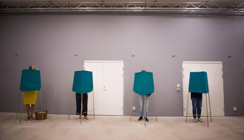 People vote in polling booths during election day in Stockholm, Sunday Sept. 9, 2018. Voters in Sweden appear to be split in an unpredictable general election that may turn into one of the most thrilling races in the Scandinavian country's history for decades amid heated debate on immigration. (Hanna Franzen/TT News Agency via AP)