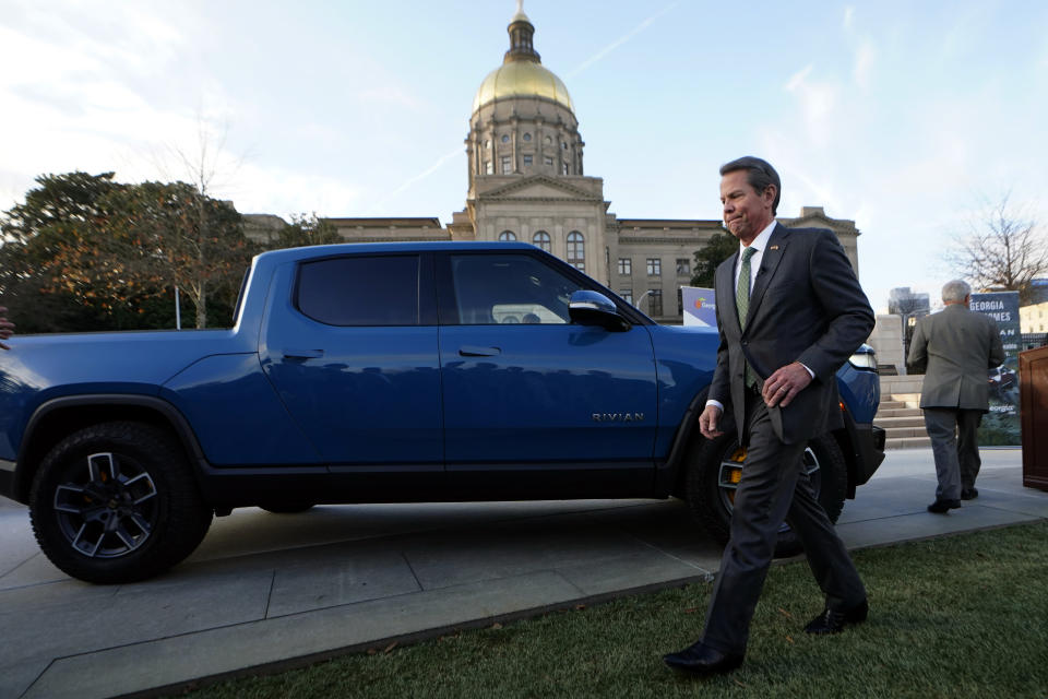 FILE - Georgia Gov. Brian Kemp walks past a Rivian electric truck, Dec. 16, 2021, in Atlanta. Electric truck maker Rivian says it's pausing construction of a $5 billion manufacturing plant in Georgia. The announcement Thursday, March 7, 2024 put the brakes on Georgia's second-largest economic development project, which came with $1.5 billion in incentives from the state and local governments. (AP Photo/John Bazemore, file)