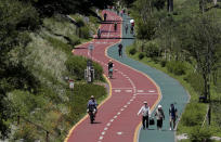 Visitors wearing face masks to help protect against the spread of the new coronavirus take a walk at a park in Seoul, South Korea, Wednesday, July 15, 2020. (AP Photo/Lee Jin-man)