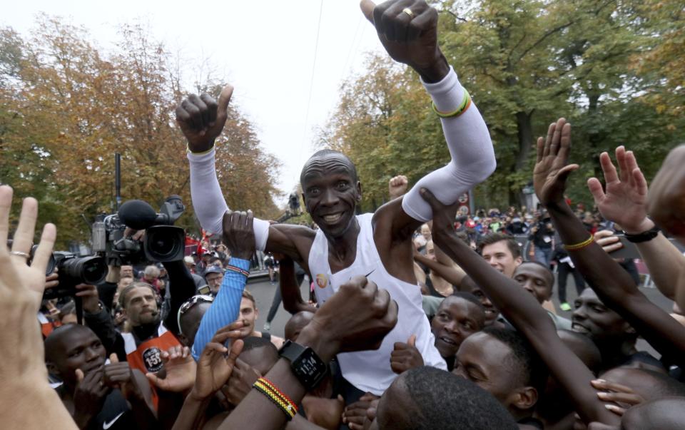 El maratonista keniano Eliud Kipchoge festeja tras registrar un tiempo de 1:59:40 en Viena, el sábado 12 de octubre de 2019. Kipchohe es el primer atleta que baja de las 2 horas en un maratón. (AP Foto/Ronald Zak)