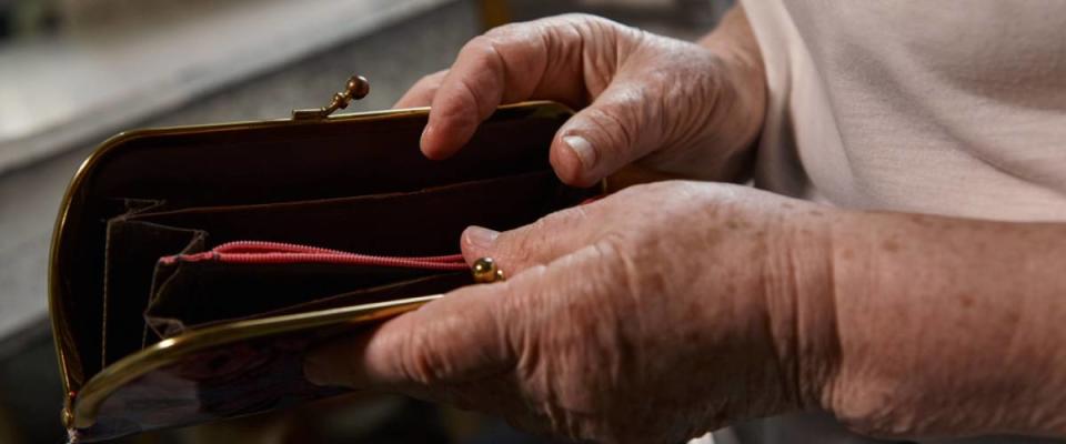 An older woman's hands opening a wallet