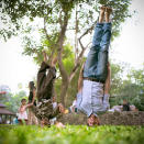 <p>Morris and a friend do twin headstands in a park while children look on. </p> <a href="http://www.stcm.co.uk/" rel="nofollow noopener" target="_blank" data-ylk="slk:(Photo by Caulton Morris);elm:context_link;itc:0;sec:content-canvas" class="link ">(Photo by Caulton Morris)</a>