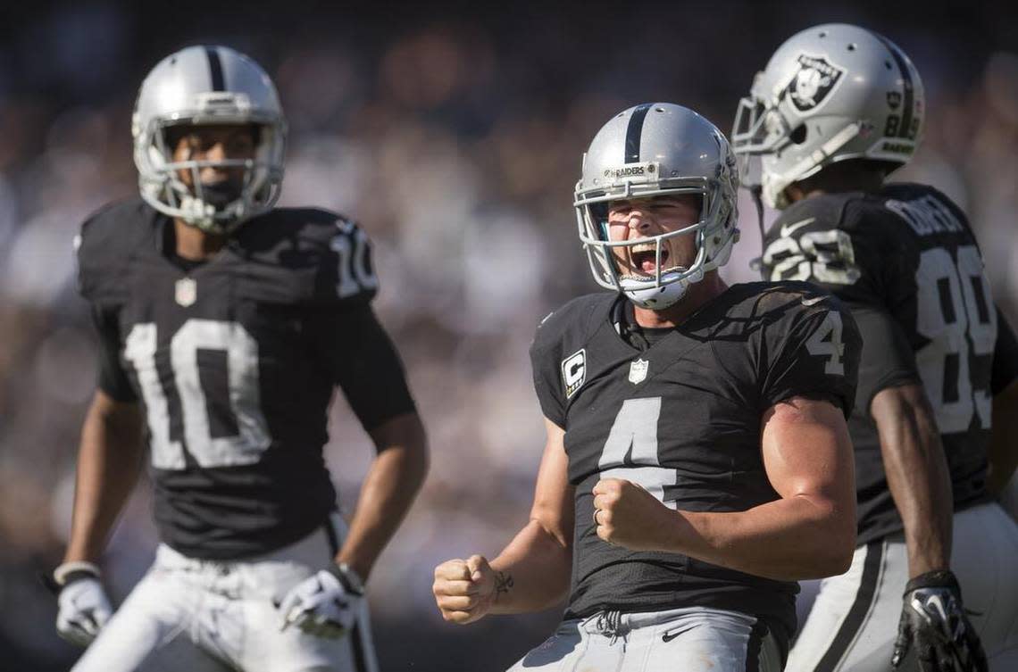 Raiders quarterback Derek Carr (4) celebrates after game-winning touchdown pass to Seth Roberts (10) in the fourth quarter as Oakland beat the Baltimore Ravens 37-33 in an NFL football game on Sunday, Sept. 20, 2015 at O.co Coliseum in Oakland.