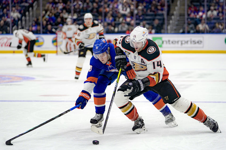 New York Islanders right wing Simon Holmstrom (10) and Anaheim Ducks center Adam Henrique (14) battle for the puck during the third period of an NHL hockey game in Elmont, N.Y., Wednesday, Dec. 13, 2023. The Islanders won, 4-3. (AP Photo/Peter K. Afriyie)