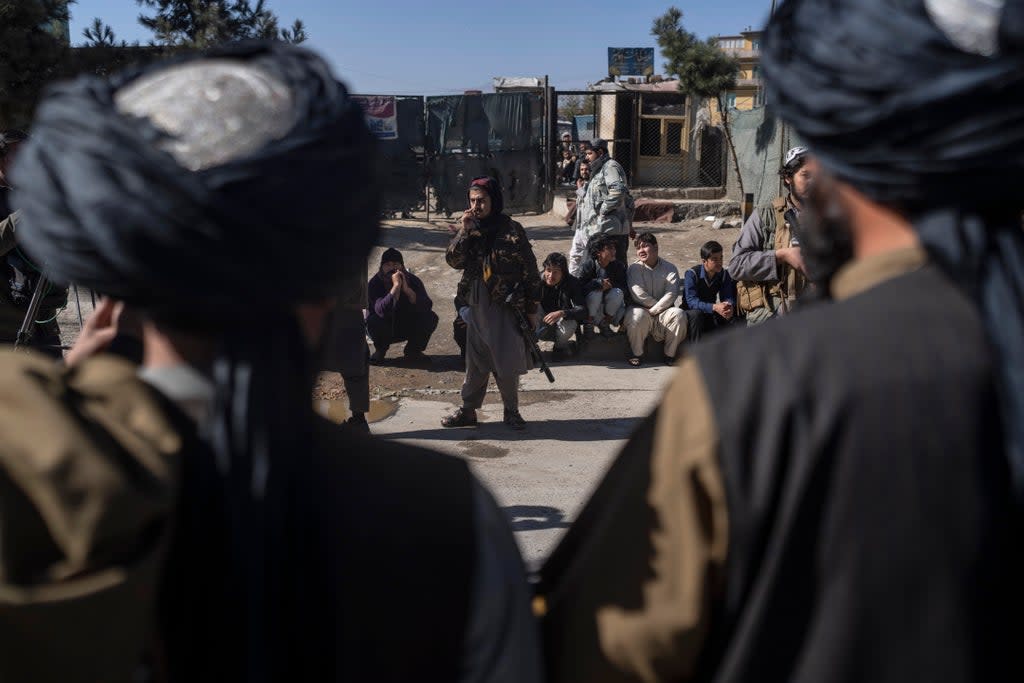 Taliban fighters secure the area after a roadside bomb went off in Kabul earlier this month (AP)
