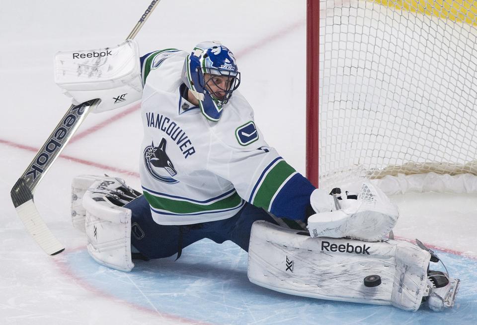 Vancouver Canucks goaltender Roberto Luongo makes a save against the Montreal Canadiens during the second period of an NHL hockey game Thursday, Feb. 6, 2014, in Montreal. (AP Photo/The Canadian Press, Graham Hughes)