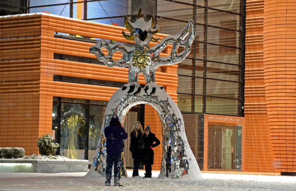 Benedikte Soegaard, left and DC Covington, right, pose for Joel Boulos under the snow-covered Firebird statue outside the Bechtler Museum of Modern Art in uptown Charlotte, NC on Saturday, January 22, 2022. Charlotte could see another inch or more of snow on Friday night, Jan. 28, 2022, a National Weather Service meteorologist said.