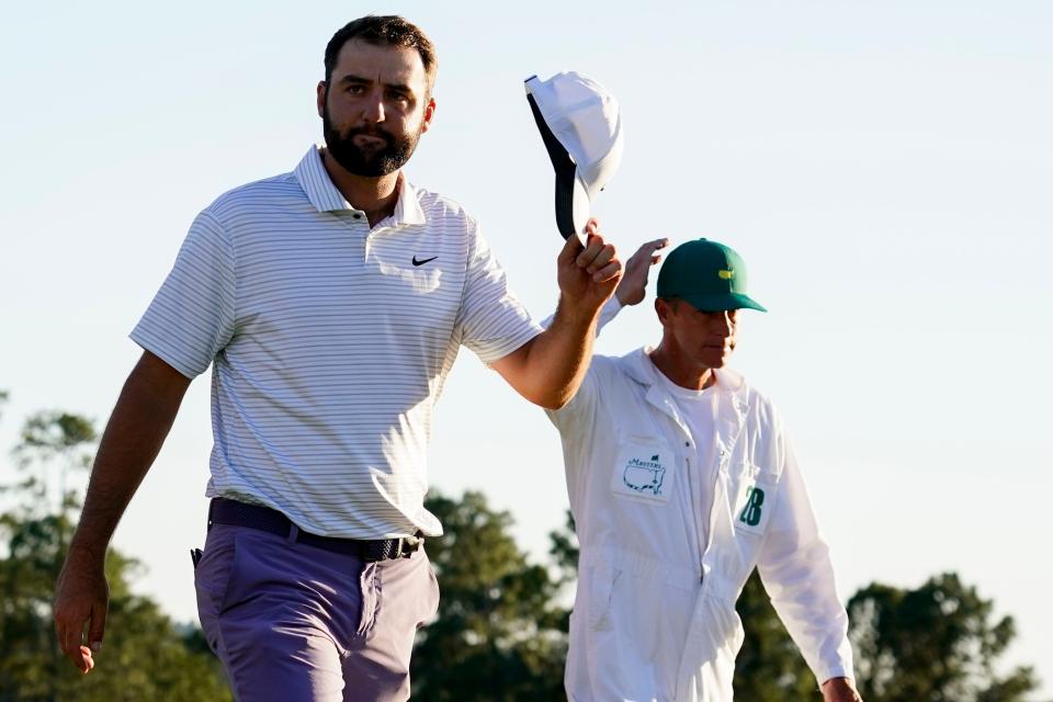 Scottie Scheffler tips his hat to patrons as he walks off the No. 18 green during the third round of the Masters Tournament.