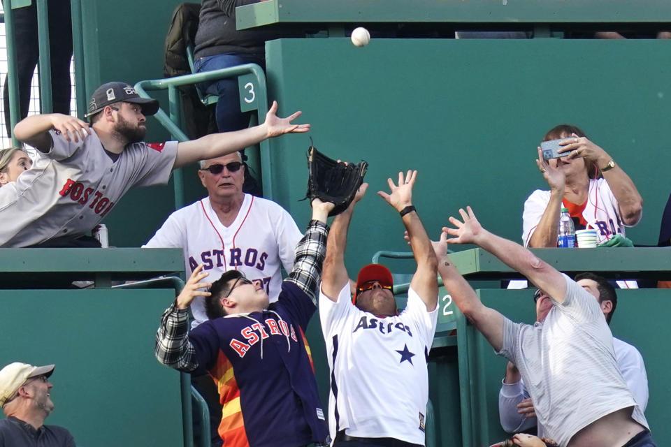 Fans try to make the catch on a home run by Houston Astros' Jose Altuve during the first inning of the team's baseball game against the Boston Red Sox at Fenway Park, Wednesday, May 18, 2022, in Boston. (AP Photo/Charles Krupa)