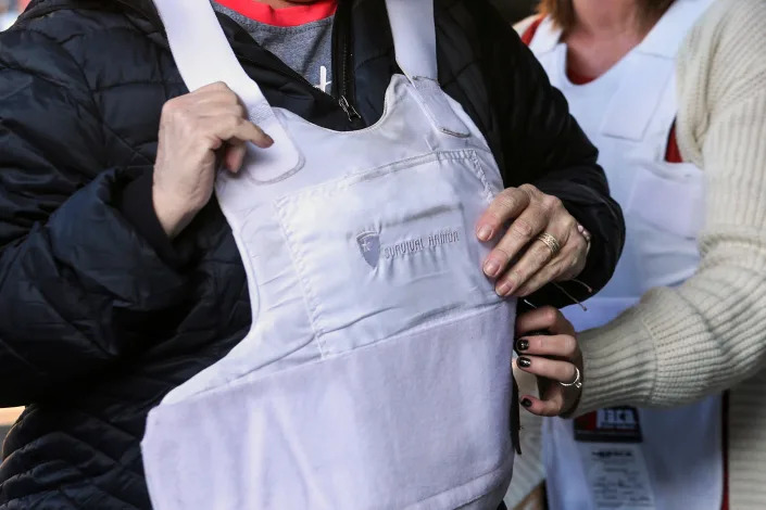 A teacher puts on a bulletproof vest during a live fire training session in Thistle, Utah,  on Saturday, Oct. 5, 2019. (George Frey / Bloomberg via Getty Images file)