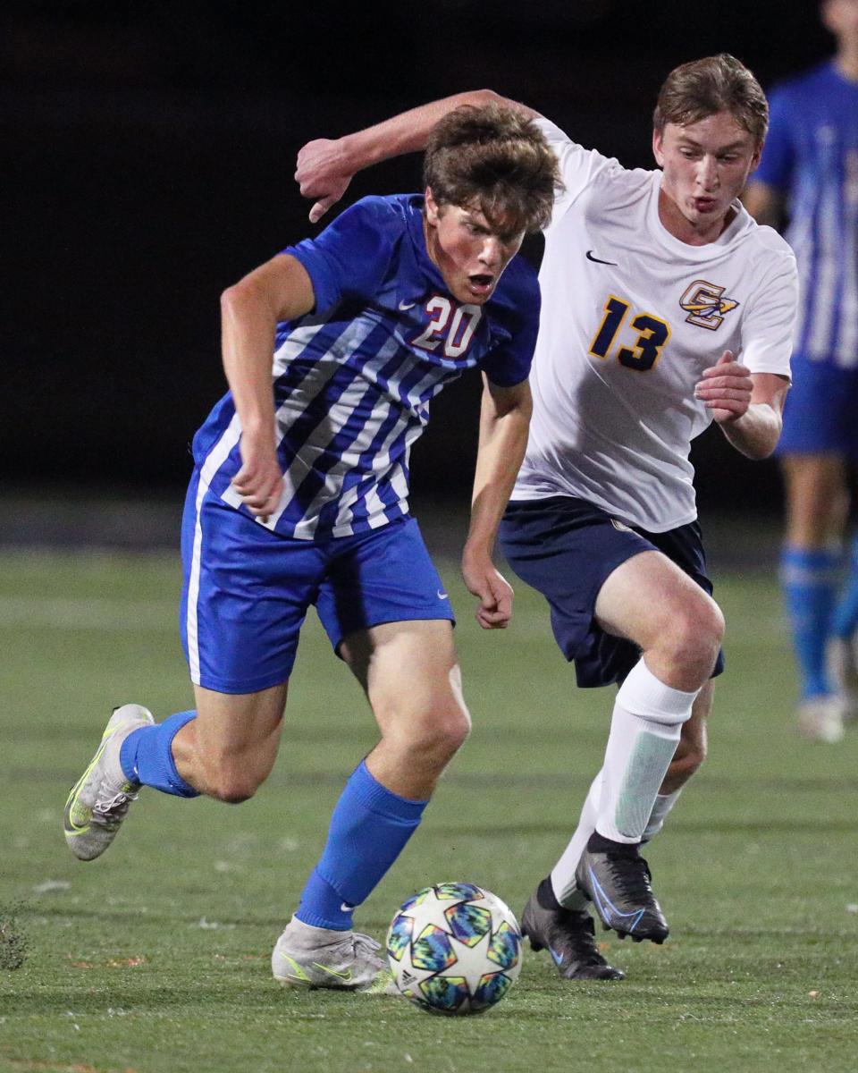 Lenawee Christian's Brady McKelvey pushes the ball up the field while Grass Lake's Jacob Colesa chases during Monday's Division 4 district match at Tecumseh.