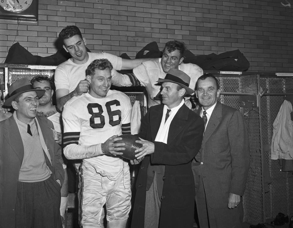 Dub Jones is given the game ball after he accounted for all the Browns TDs in their 42-21 romp over the Bears in 1951. Left to right (front): Jones; Paul Brown and Blanton Collier, backfield coach. Rear: QB Otto Graham and Capt. Tony Adamle. (Associated Press)