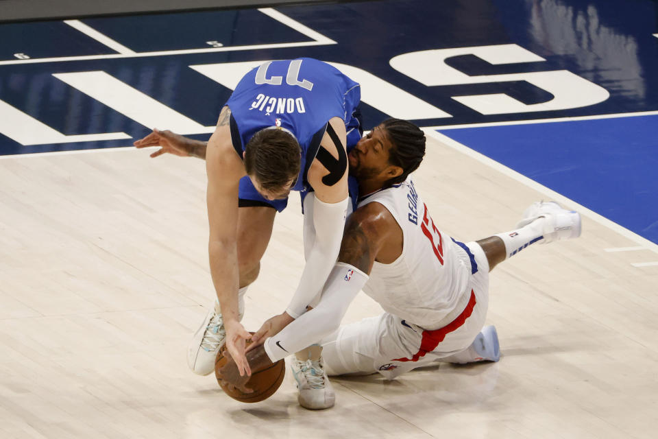 Dallas Mavericks guard Luka Doncic (77) and Los Angeles Clippers guard Paul George (13) go for the ball in the first half during Game 6 of an NBA basketball first-round playoff series in Dallas, Friday, June 4, 2021. (AP Photo/Michael Ainsworth)