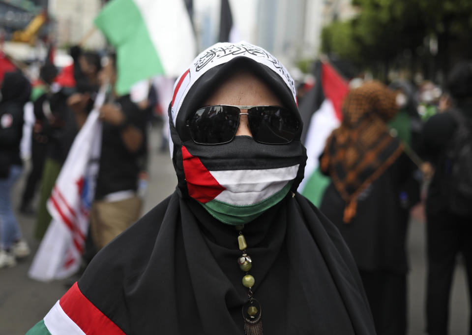 A Muslim woman wears a face mask with the colors of Palestinian flag during a rally condemning Israeli attacks on the Palestinians in Jakarta, Indonesia, Tuesday, May 18, 2021. (AP Photo/Dita Alangkara)