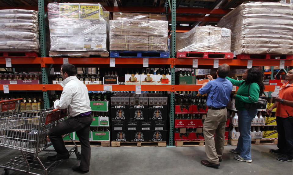 Customers shop for liquor at a Costco warehouse store Friday, June 1, 2012, in Seattle. Private retailers begin selling spirits for the first time under a voter-approved initiative kicking the state out of the liquor business. The initiative allows stores larger than 10,000 square feet and some smaller stores to sell hard alcohol.(AP Photo/Elaine Thompson)