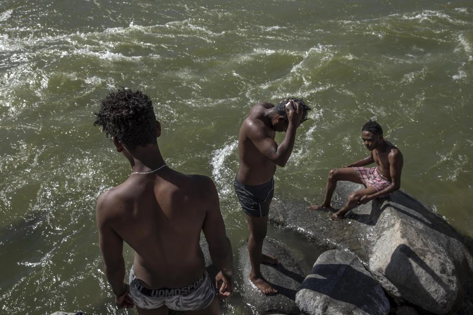 Tigray refugees who fled the conflict in the Ethiopia's Tigray bathe themselves on the banks of the Tekeze River on the Sudan-Ethiopia border, in Hamdayet, eastern Sudan, Tuesday, Dec. 1, 2020. (AP Photo/Nariman El-Mofty)