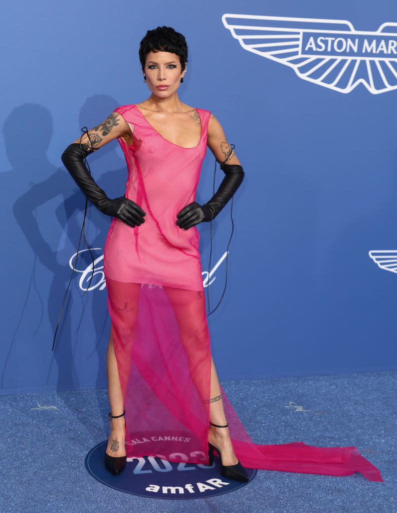 Halsey is wearing a semi-sheer sleeveless dress and long gloves