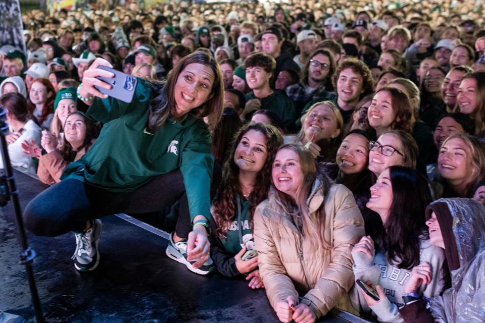 MSU women's basketball coach Robyn Fralick takes a selfie with student fans during Izzone Campout at Munn Field near Breslin Center in East Lansing on Friday, Oct. 6, 2023.