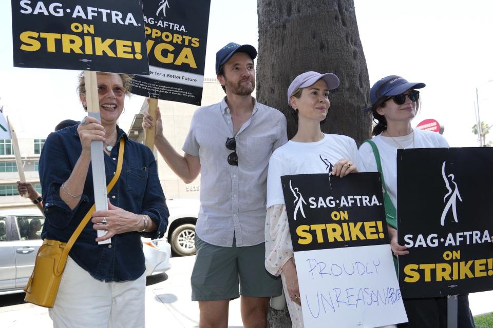 Actors Annette Bening, Jason Butler Harner, Sarah Paulson, and Elizabeth Reaser appear on a picket line outside Netflix studios on July 25, 2023, in Los Angeles. The actors strike comes more than two months after screenwriters began striking in their bid to get better pay and working conditions.