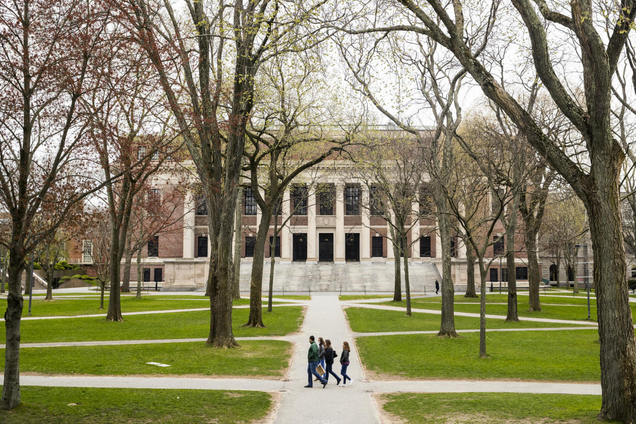 Pedestrians walk through Harvard Yard in Cambridge, Mass., on April 20, 2020. (Adam Glanzman / Bloomberg via Getty Images file)