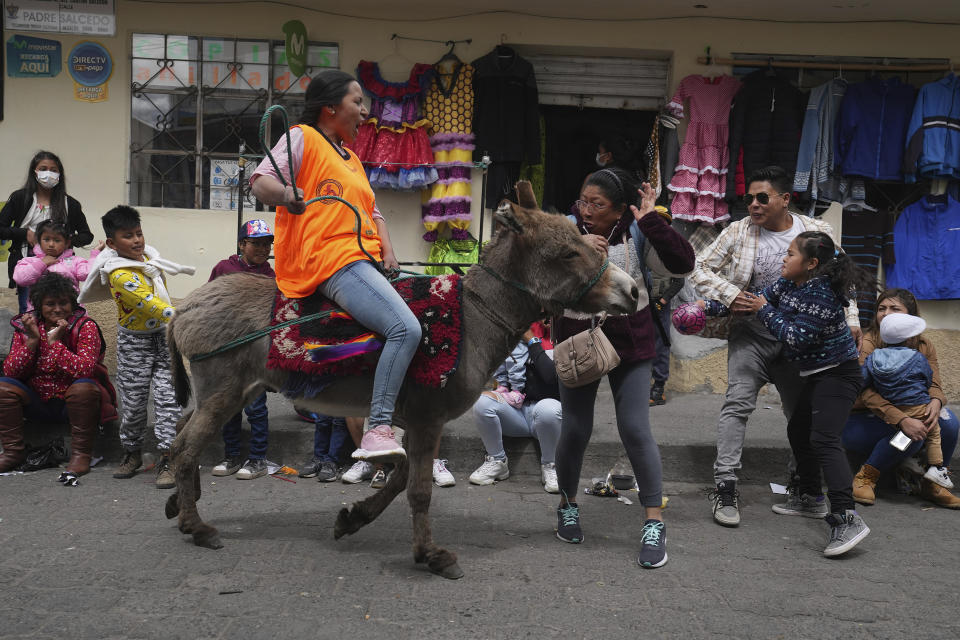 Spectators react as a competitor races past in the annual donkey festival in Salcedo, Ecuador, Saturday, Sept. 10, 2022. (AP Photo/Dolores Ochoa)