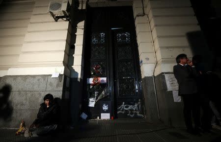 A man sits next to a portrait of Santiago Maldonado, a protester who went missing since security forces clashed with indigenous activists in Patagonia on August 1, 2017, at the entrance of a judicial morgue in Buenos Aires, Argentina October 20, 2017. REUTERS/Marcos Brindicci