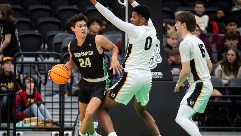 Snow Canyon’s Owen Mackay (24) looks to pass the ball out while guarded by Cottonwood forward Christopher Cox (0) during a 4A boys basketball state semifinals game at the UCCU Center in Orem on Tuesday, Feb. 27, 2024.