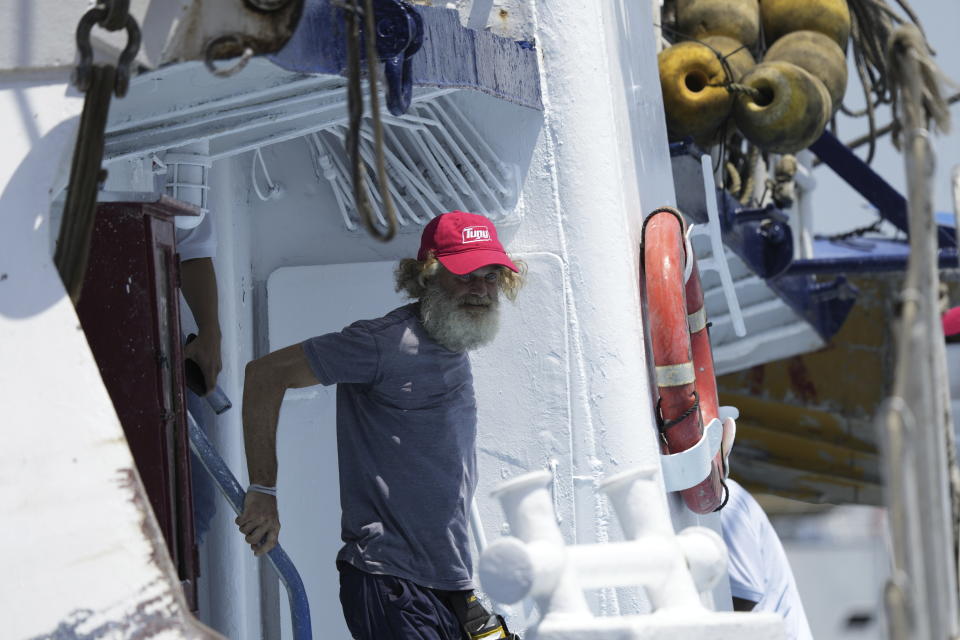 El australiano Timothy Lyndsay Shaddock baja del atunero María Delia que les rescató a él y a su perra Bella, en el puerto de Manzanillo, México, el martes 18 de julio de 2023. (AP Foto/Fernando Llano)