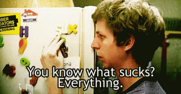 A sad teenager plays with letter magnets on a refrigerator