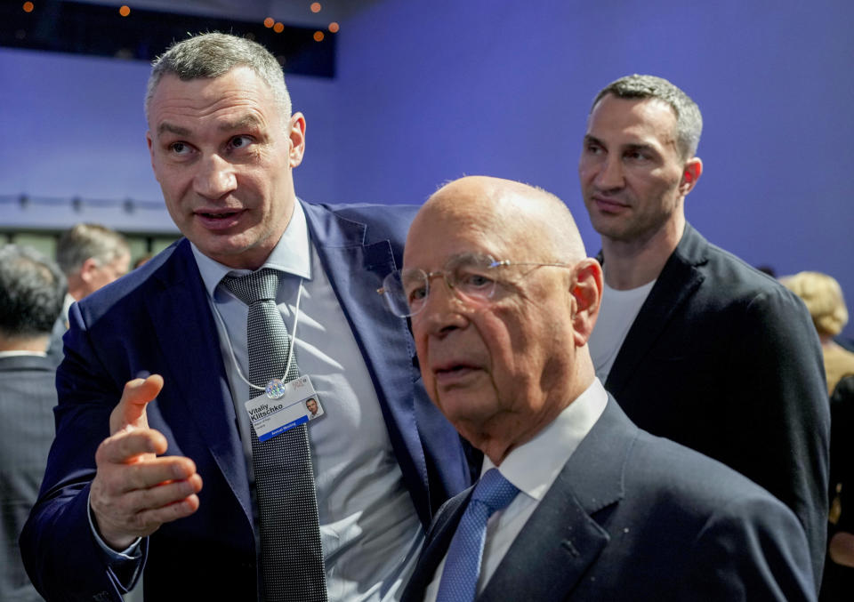 Kyiv Mayor Vitali Klitschko, left, and his brother Wladimir talk to Forum founder Klaus Schwab during the World Economic Forum in Davos, Switzerland, Monday, May 23, 2022. The annual meeting of the World Economic Forum is taking place in Davos from May 22 until May 26, 2022. (AP Photo/Markus Schreiber)