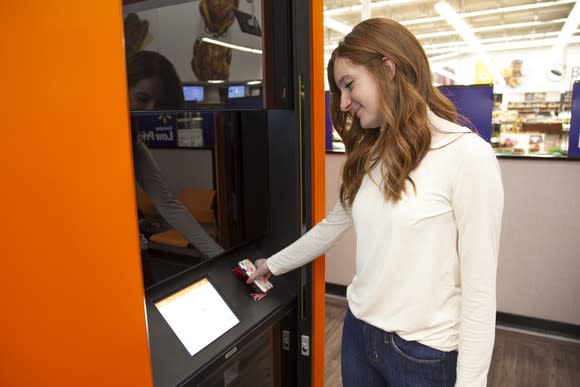 A Walmart customer picking up an order at a Pickup Tower.