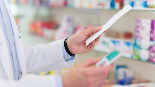 Pharmacist holding prescription.