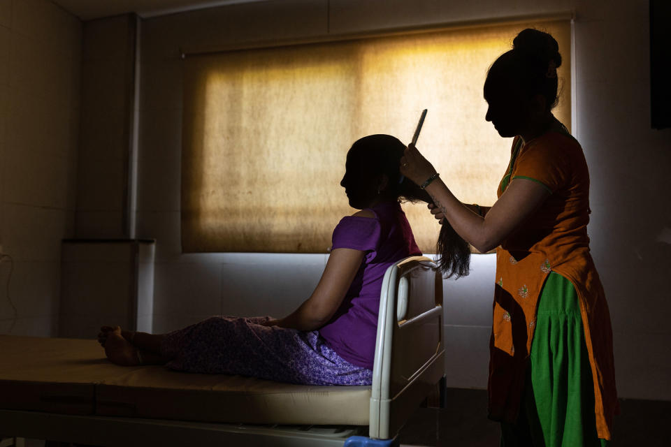 First-time surrogate Heena Sodaparmar combs the hair of Neha Makwana, who is at Akanksha for the second time to save money for her family.<span class="copyright">Smita Sharma for TIME</span>