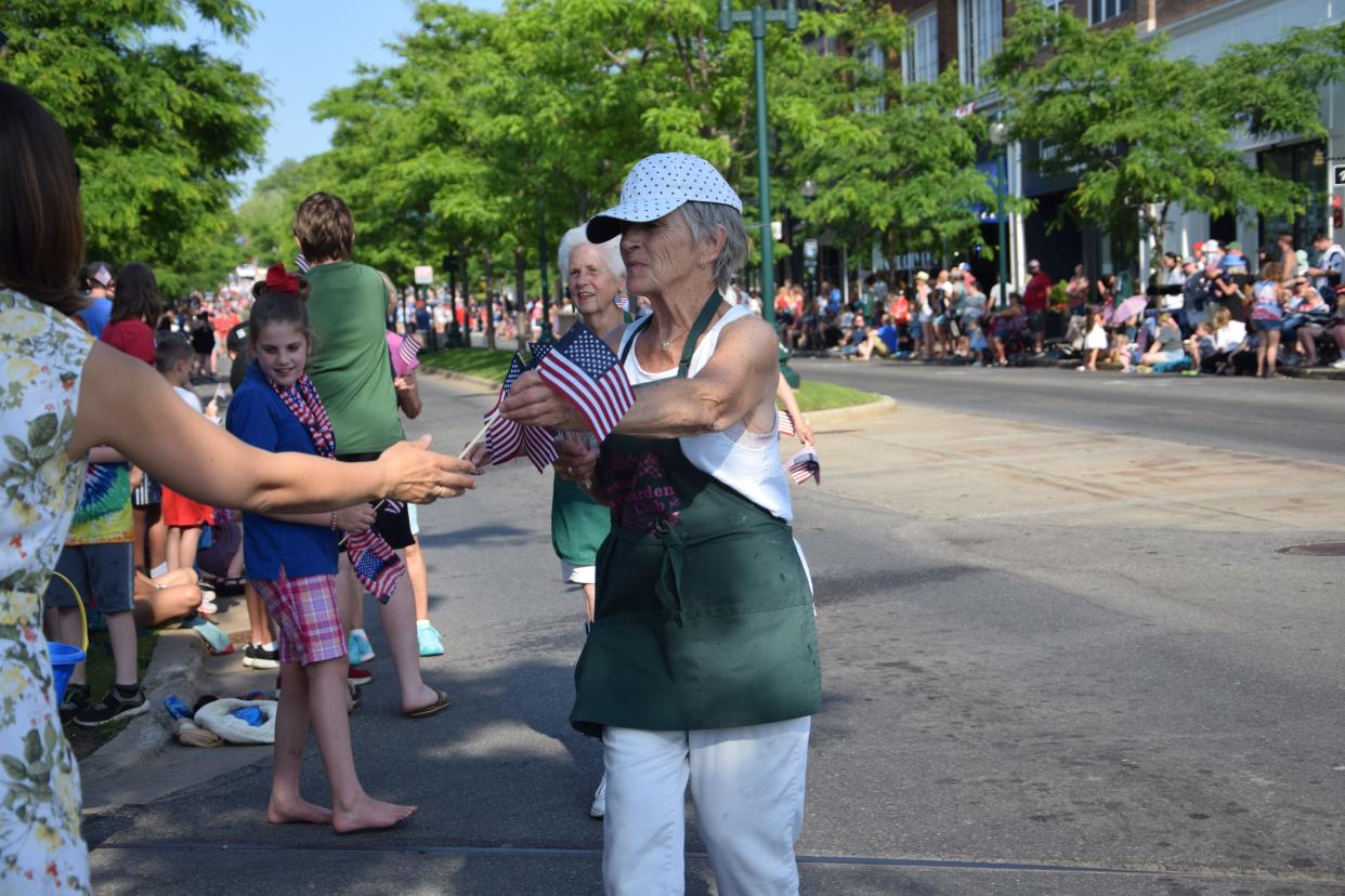 Members of the Petoskey Area Garden Club hand out flags during the 2023 Fourth of July parade.