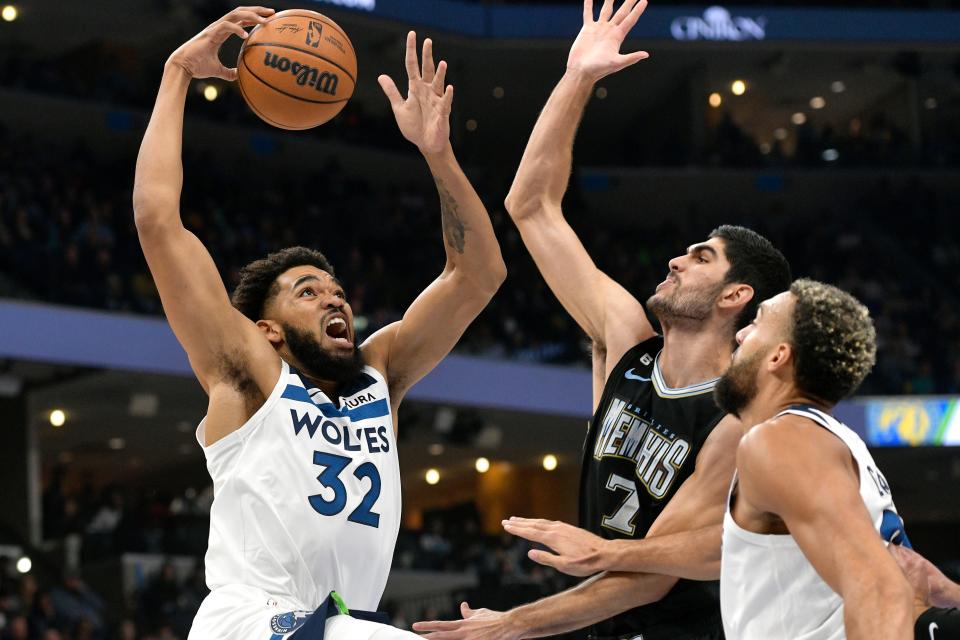 Minnesota Timberwolves center Karl-Anthony Towns (32) shoots against Memphis Grizzlies forward Santi Aldama (7) as center Rudy Gobert moves for position during the first half of an NBA basketball game Friday, Nov. 11, 2022, in Memphis, Tenn. (AP Photo/Brandon Dill)