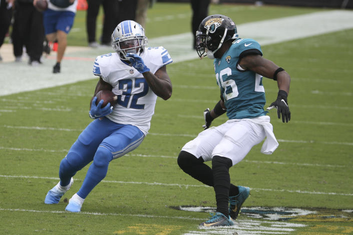 Detroit Lions running back D'Andre Swift (32) tries to avoid a tackle by Jacksonville Jaguars safety Jarrod Wilson, right, during the first half of an NFL football game, Sunday, Oct. 18, 2020, in Jacksonville, Fla. (AP Photo/Stephen B. Morton)