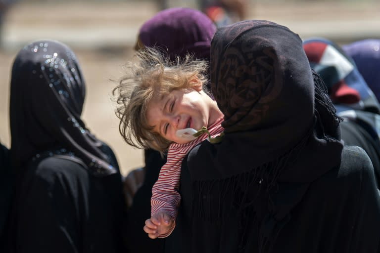 Women and children queue up at a mobile clinic in West Mosul on April 25, 2017