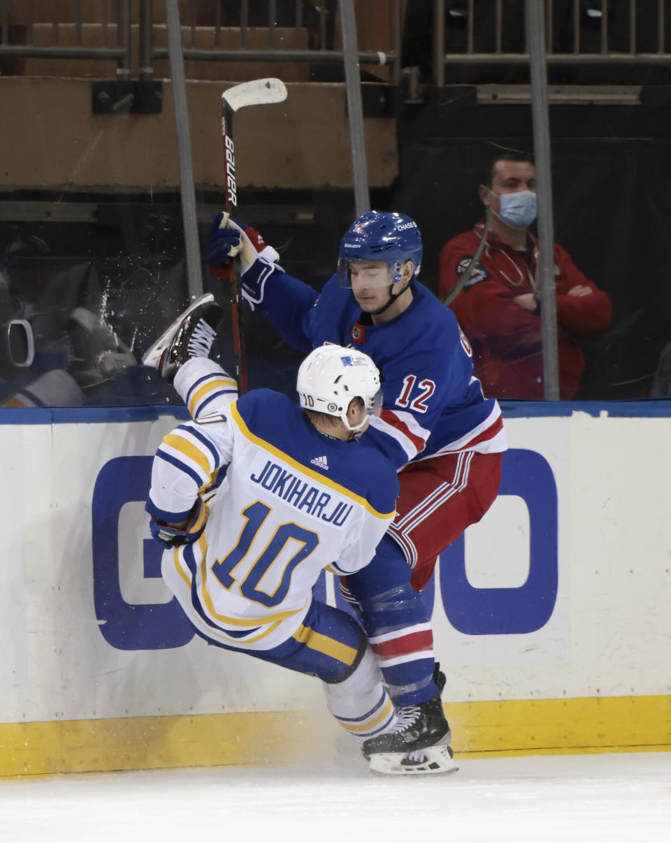 New York Rangers' Julien Gauthier (12) checks Buffalo Sabres' Henri Jokiharju (10 during the second period of an NHL hockey game Tuesday, March 2, 2021, in New York. (Bruce Bennett/Pool Photo via AP)