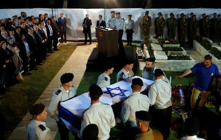 People carry the coffin of Zachary Baumel, a U.S.-born Israeli soldier missing since a 1982 tank battle against Syrian forces and whose remains were recently recovered by Israel, as Israeli Prime Minister Benjamin Netanyahu and Israeli President Reuven Rivlin attend his funeral at the Mount Herzl military cemetery in Jerusalem April 4, 2019. REUTERS/Ronen Zvulun